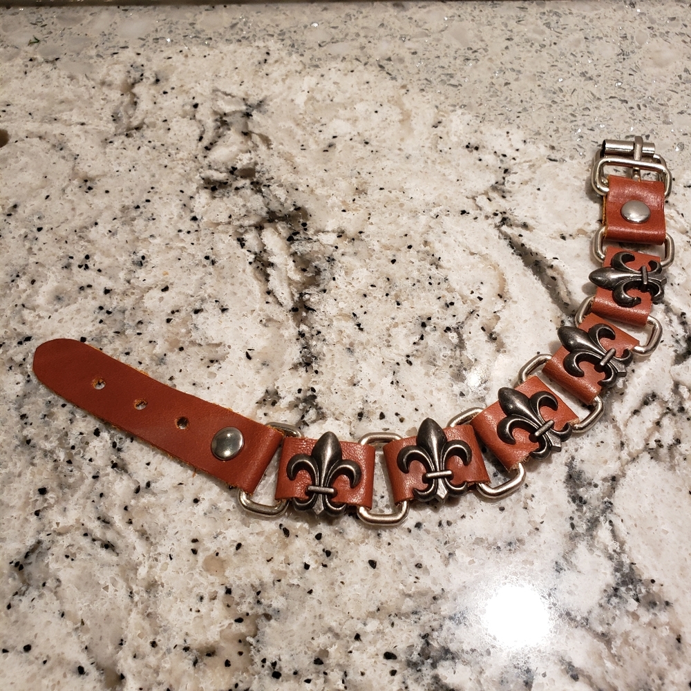 Fleur-de-lis leather and metal bracelet.
